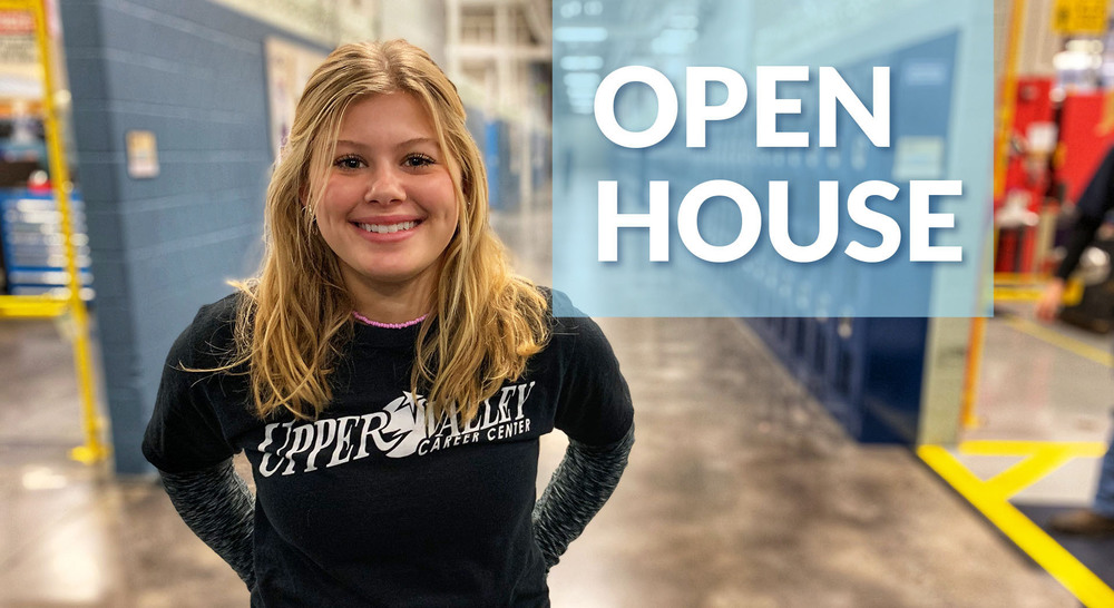 Smiling student welcomes guests to open house