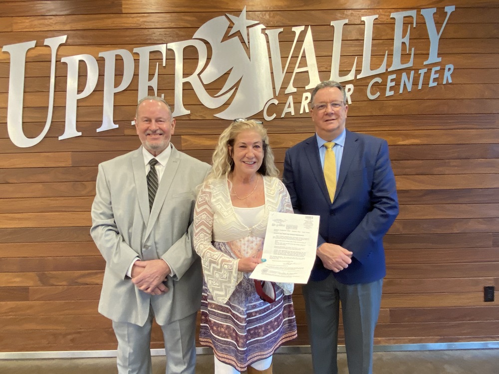 Mindy Hartzel (center) of Craft Interiors presents a residential building lot deed to Mr. Patrick Gibson, Director of Business Operations for Upper Valley Career Center. Also in attendance from Craft Interiors is Terry Stamper, (left). 